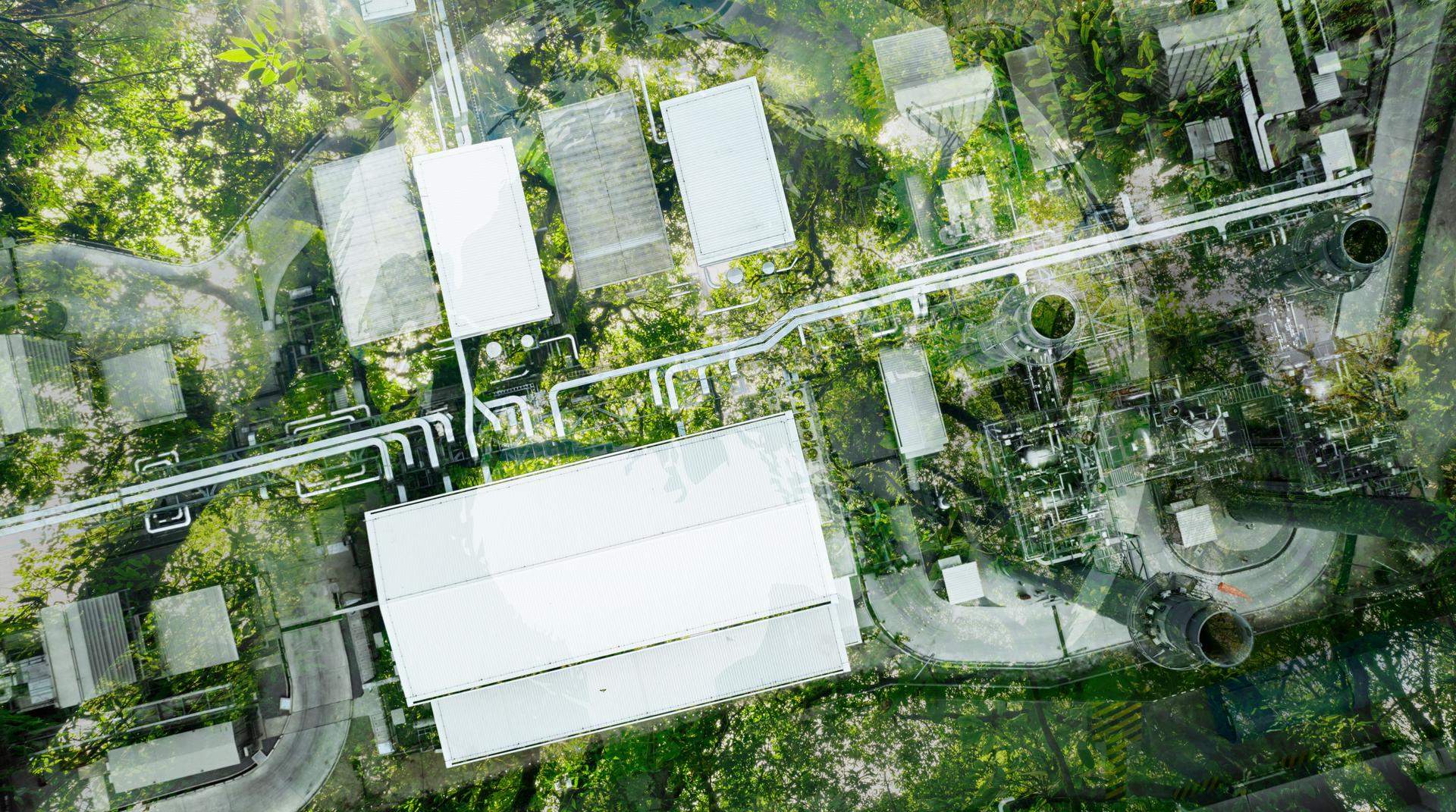Aerial view factory roof amidst lush green tree forest. Sustainable practices for carbon reduction of factories. Sustainability in manufacturing. Carbon offsets and eco-friendly industrial practices.